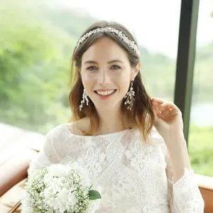 Detail of bridal lace headband and matching tassel earrings with white pearls and beads