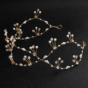 Detail von handgefertigtem Haarschmuck aus Golddraht mit weißen Perlen und Kristallen