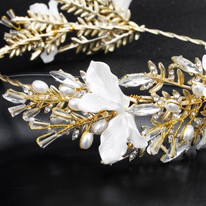 Detailansicht eines Brautstirnbands mit Golddraht, weißen Blumen, Perlen und Kristallen