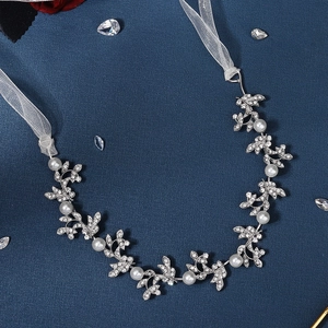 Détail du bandeau de mariée avec feuilles argentées, perles et strass scintillants