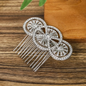 Vintage silver bridal hair comb with rhinestone circles on a dark wooden background