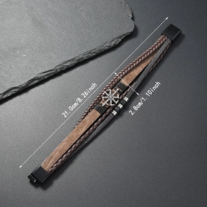 Détail du bracelet en cuir multicouche avec breloque gouvernail et fermoir magnétique
