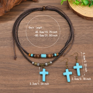 Vue à plat de bijoux vintage avec croix turquoise sur fond de bois sombre