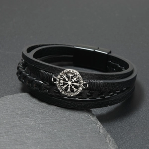 Close-up of men's layered leather bracelet featuring a silver Viking compass metal emblem