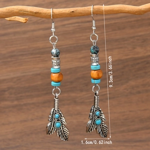Detail of vintage bohemian bull head earrings with turquoise beads and metal feathers