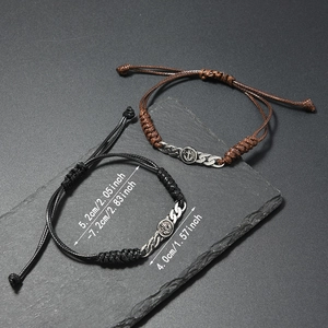 Detail verstellbarer geflochtener Kordelarmbänder mit Ankeranhängern auf Steingrund