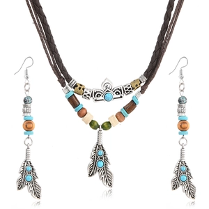 Détail d'ensemble bohème avec perles en bois, turquoise et pendentifs plumes argent