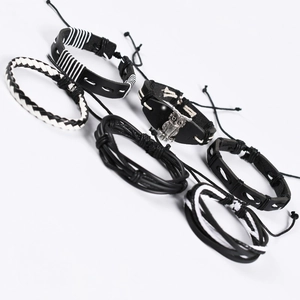 Detail of 6-piece multilayer leather bracelet set with owl charm and woven punk bands