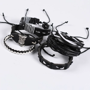 Close-up of multilayer leather bracelets with owl charm and woven punk design details