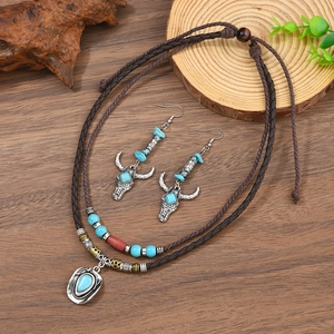 Détail de parure bijoux western avec perles turquoise et boucles tête de taureau