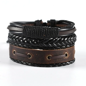 Detail of vintage multilayer leather bracelets with woven straps and metal rivets