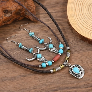Détail de collier en cuir perlé bohème et boucles d'oreilles tête de taureau western