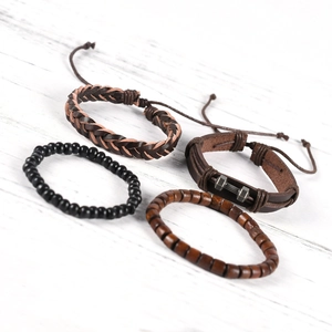 Men's multilayer leather bracelet set with dumbbell charm on a white wooden background
