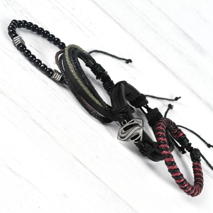 Macro shot of vintage layered leather bracelets featuring Superman logo shield charm