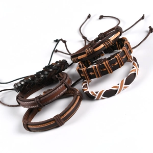 Detail of stacked multi-layer woven leather bracelets with owl wing charms and adjustable cords