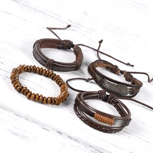 Men's multilayer leather bracelet set with wing charm and wooden beads on wood base
