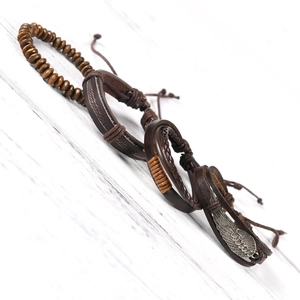 Men's retro multilayer leather bracelet set with wing charm on white wood background