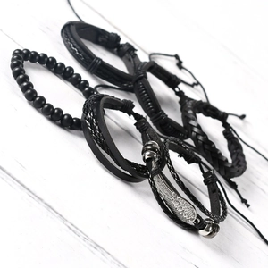 Close-up of punk style multi-layer braided leather bracelets with silver wing charm