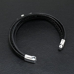 Detail of multi-layer woven black leather bracelet with silver magnetic metal clasp