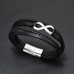 Detail of multi-layer black braided leather bracelet with silver infinity symbol and magnet clasp