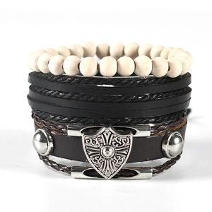 Detail view of multi-layer leather bracelet set with wooden beads and silver shield charm