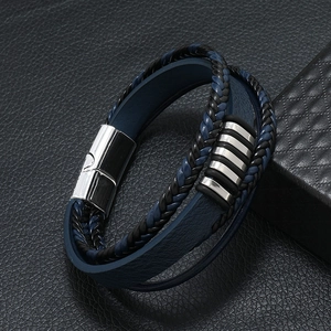 Détail d'un bracelet multicouche en cuir bleu tressé avec fermoir magnétique argenté poli