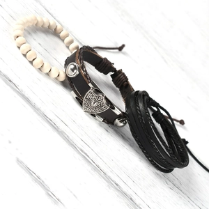 Detail shot of multi-layer leather bracelets with vintage metal shield and natural wood beads