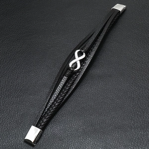 Detail view of multi-layer black braided leather bracelet with silver infinity symbol and clasp