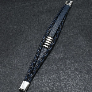 Gros plan sur un bracelet en cuir tressé pour homme avec fermoir magnétique argenté poli