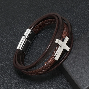 Detail of multi-layer braided leather bracelet with silver cross and magnetic clasp