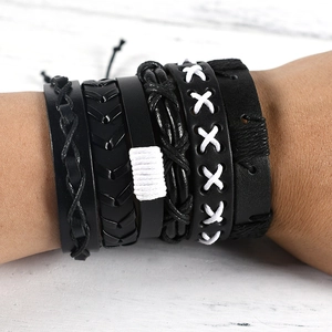 Close-up of men's multilayer black leather bracelets with woven owl wing design elements