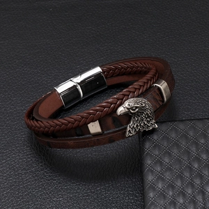 Detail of men's leather bracelet with silver eagle head charm and magnetic clasp