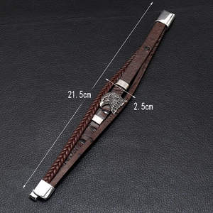Close-up of multilayer braided leather bracelet with silver eagle charm and magnetic clasp