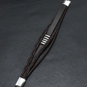 Détail d'un bracelet multicouche en cuir tressé pour homme avec fermoir magnétique