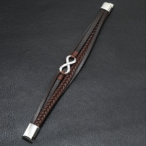 Macro shot of multi-layer braided leather bracelet with silver infinity symbol and magnetic clasp