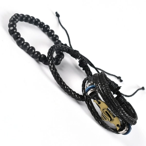 Detail view of a men's 3-piece black leather and beaded bracelet set with gold S shield