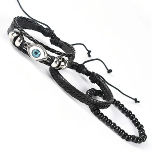 Detail of multi-layer black braided leather bracelet set with blue evil eye charm and beads