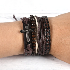 Detail of multi-layer leather bracelet with wooden beads and engraved cross charm