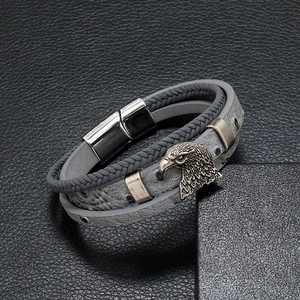 Detailed close-up of braided leather men's bracelet with metal eagle head and magnetic clasp