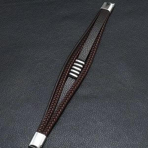 Détail d'un bracelet en cuir multicouche avec anneaux métalliques et fermoir magnétique