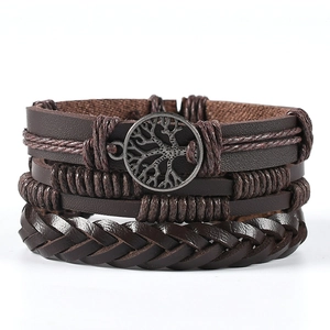 Macro detail of multilayer leather bracelet with a bronze Tree of Life charm and beads