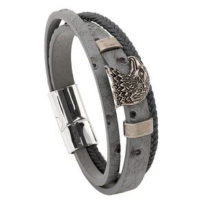 Close-up of leather woven bracelet featuring a vintage eagle head charm and magnetic clasp