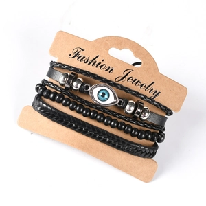 Detail of four-piece black leather bracelet set featuring blue evil eye and beads