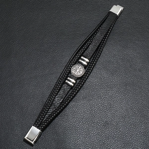 Detailed macro view of black leather woven bracelet with silver Viking Vegvísir compass badge