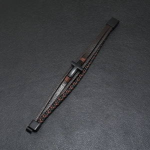 Close-up of multi-layer woven leather bracelet featuring a black matte metal cross and clasp