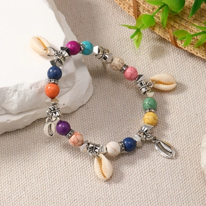 Macro detail of Bohemian colorful beaded bracelet with silver spacers and seashell charm