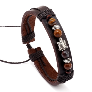 Vista dettagliata del bracciale multistrato in pelle con perle occhio di tigre e tartaruga