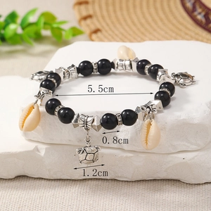 Detail showing shell and turtle charms on a beaded bracelet with 5.5cm inner diameter