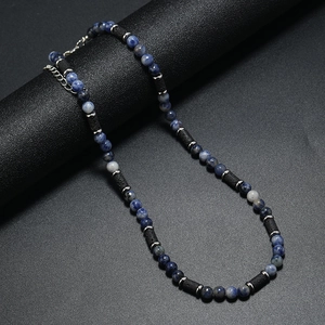 Dettaglio collana bohémien con pietre blu occhio di tigre, lava nera e distanziatori argento