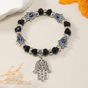Detalle macro de pulsera de cuentas con mano de Fátima y motivo de ojo turco azul